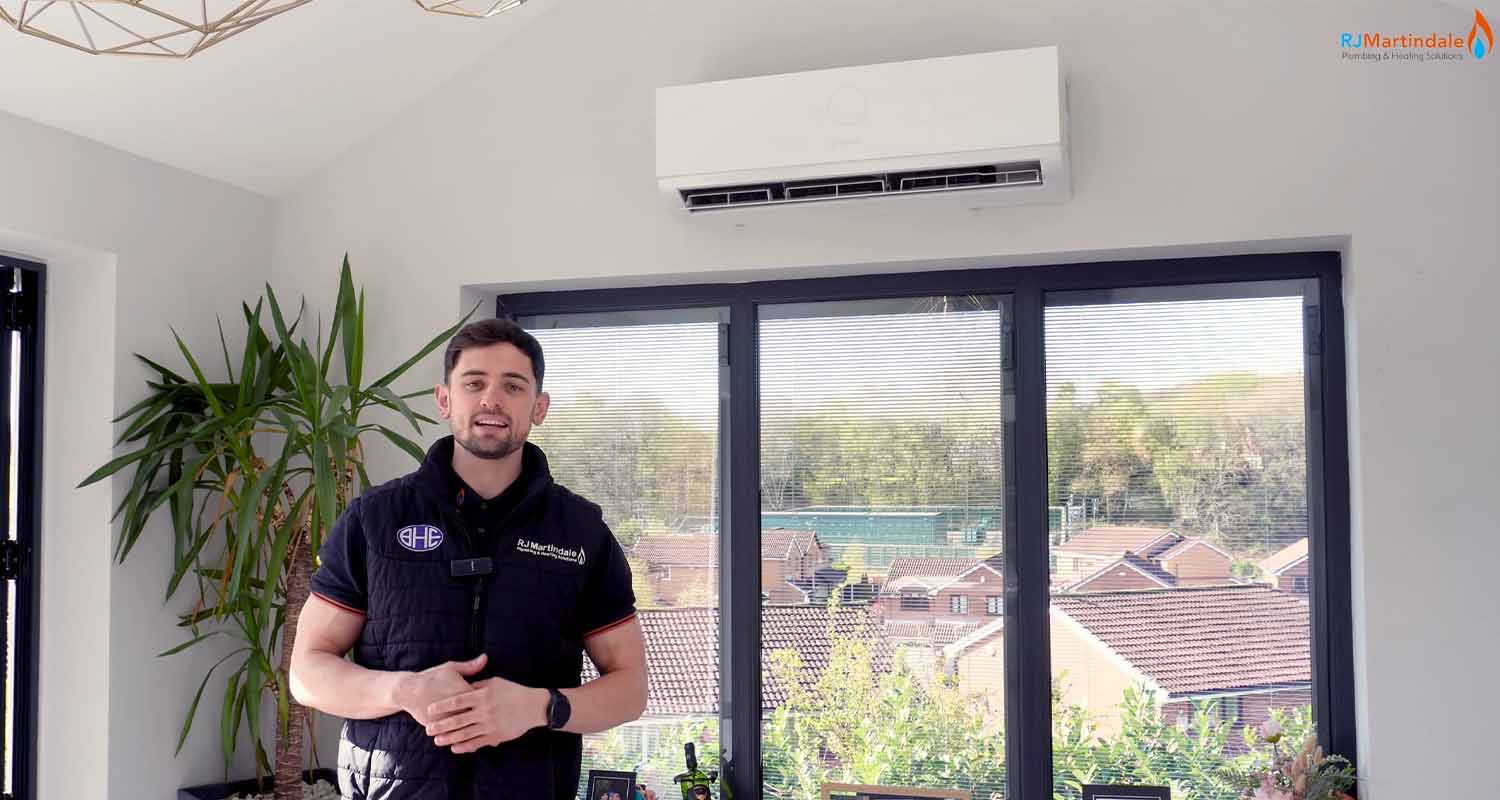 Ryan from RJ Martindale in a room with a newly installed air conditioning unit